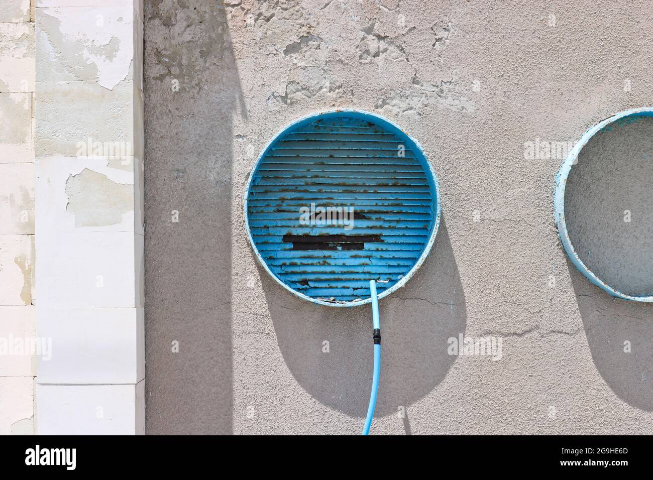 Round structures in a cement wall covered with cracked plaster. Stock Photo