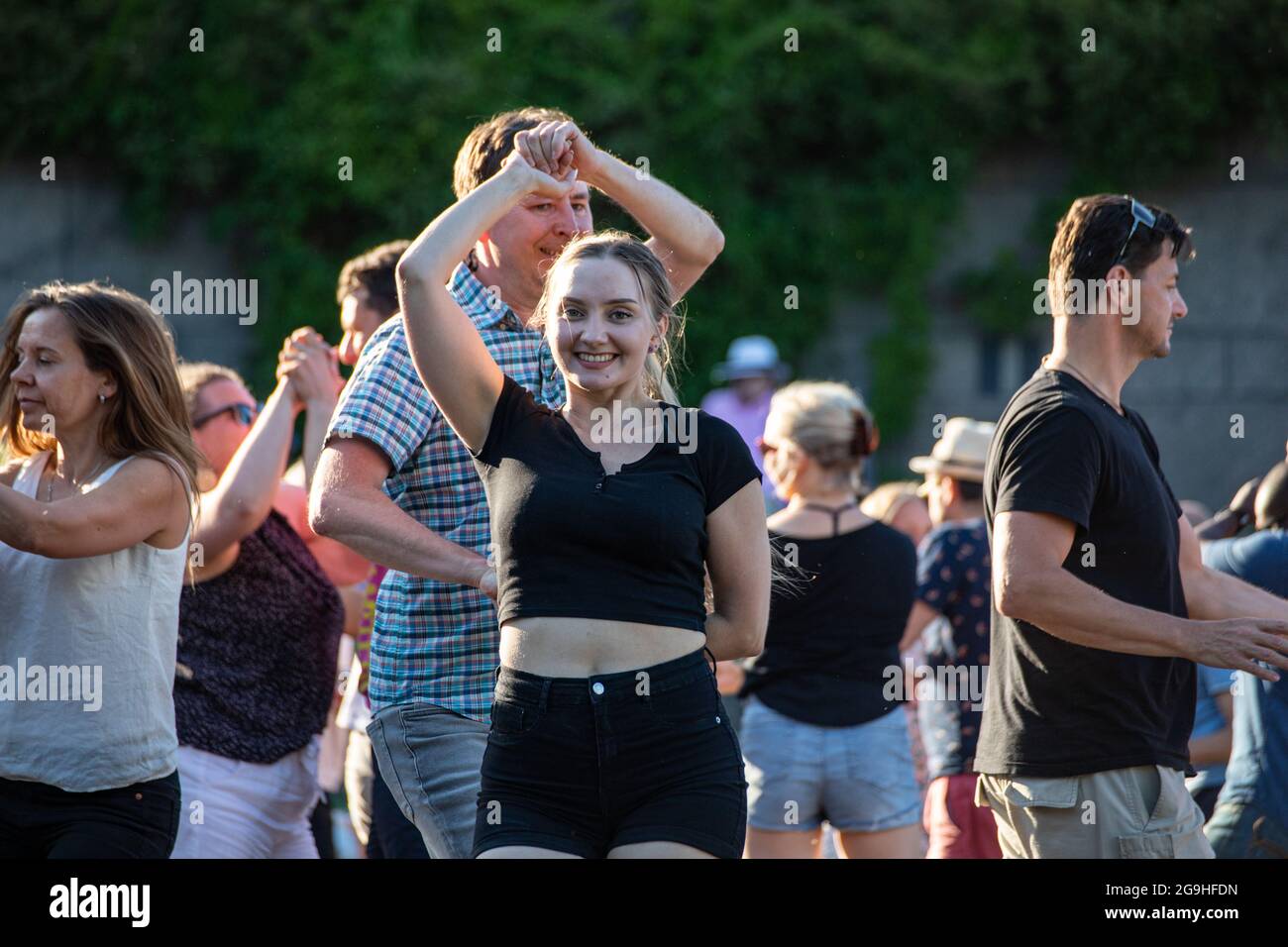 Smiling people dancing salsa in evening light at Salsa at the Opera dance party in Helsinki, Finland Stock Photo