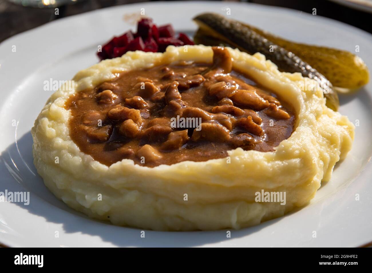 Läskisoosi, traditional Finnish pork gravy dish with mashed potatoes, pickled beatroot and pickles on a white plate Stock Photo