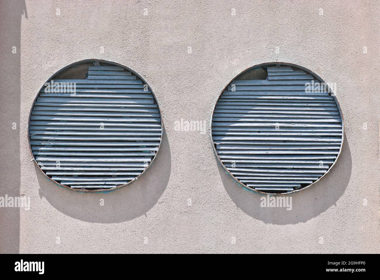 Round structures in a cement wall covered with cracked plaster. Stock Photo