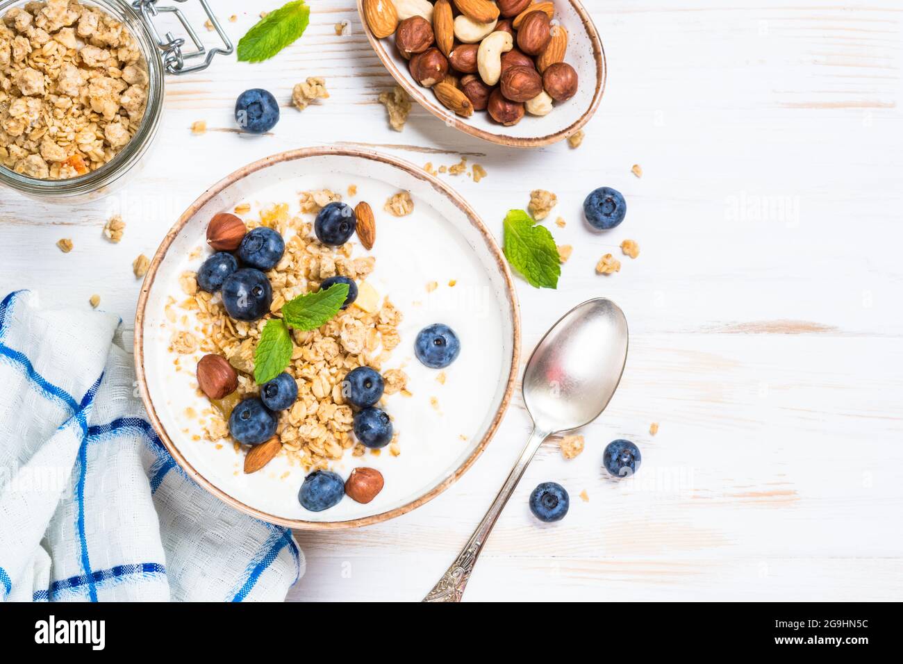 Yogurt granola with fresh blueberries on white wooden table. Stock Photo