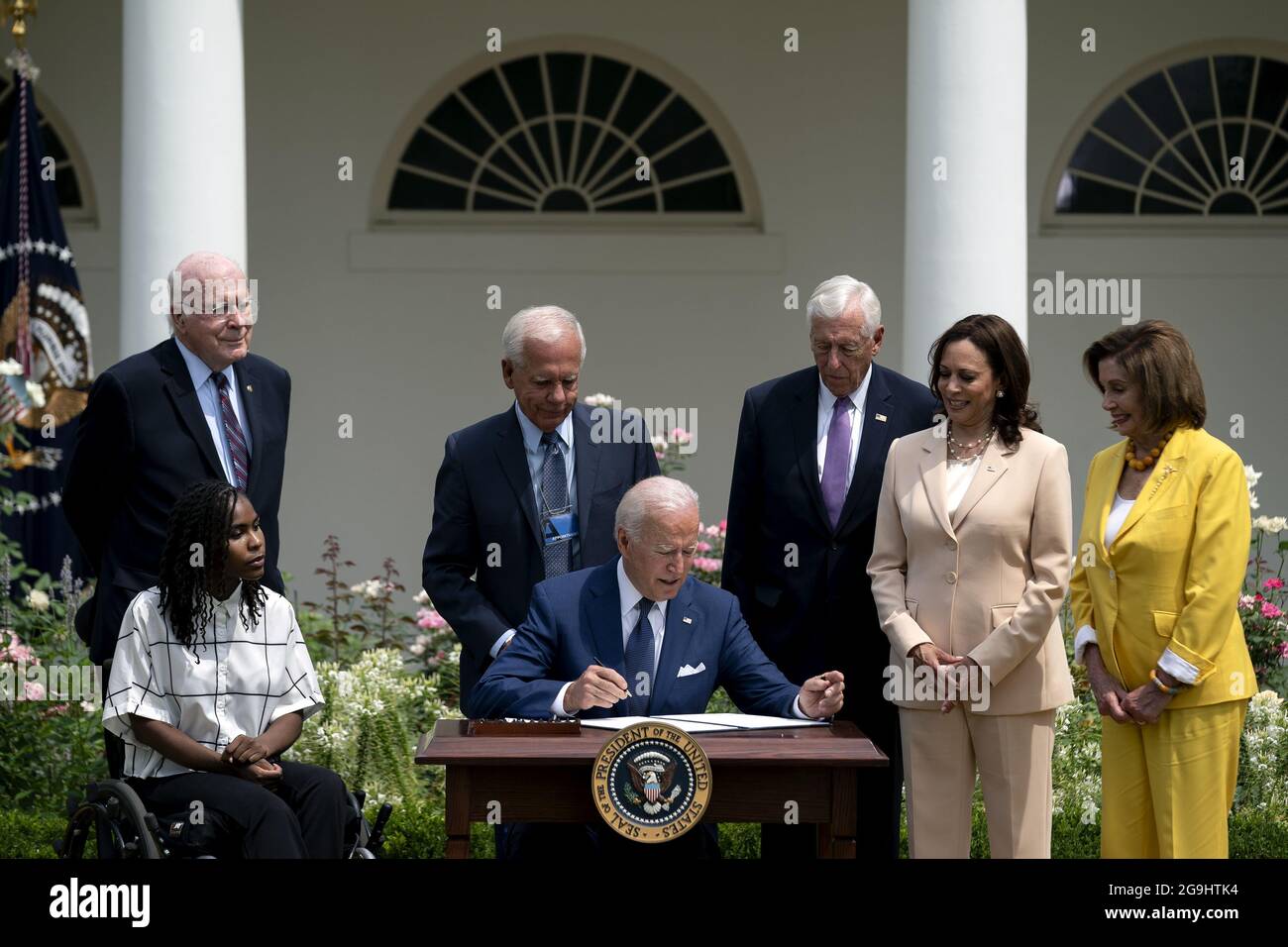 Tyree Brown, from left, Senator Patrick Leahy, a Democrat from Vermont, former Representative Tony Coelho, House Majority Leader Steny Hoyer, a Democrat from Maryland, U.S. Vice President Kamala Harris, and Speaker of the House Nancy Pelosi, a Democrat from California, applaud as U.S. President Joe Biden, center, signs a proclamation during an event marking the 31st anniversary of the Americans with Disabilities Act (ADA) in the Rose Garden of the White House in Washington, DC, U.S., on Monday, July 26, 2021. The Biden administration is keeping foreign travel restrictions in place amid conce Stock Photo