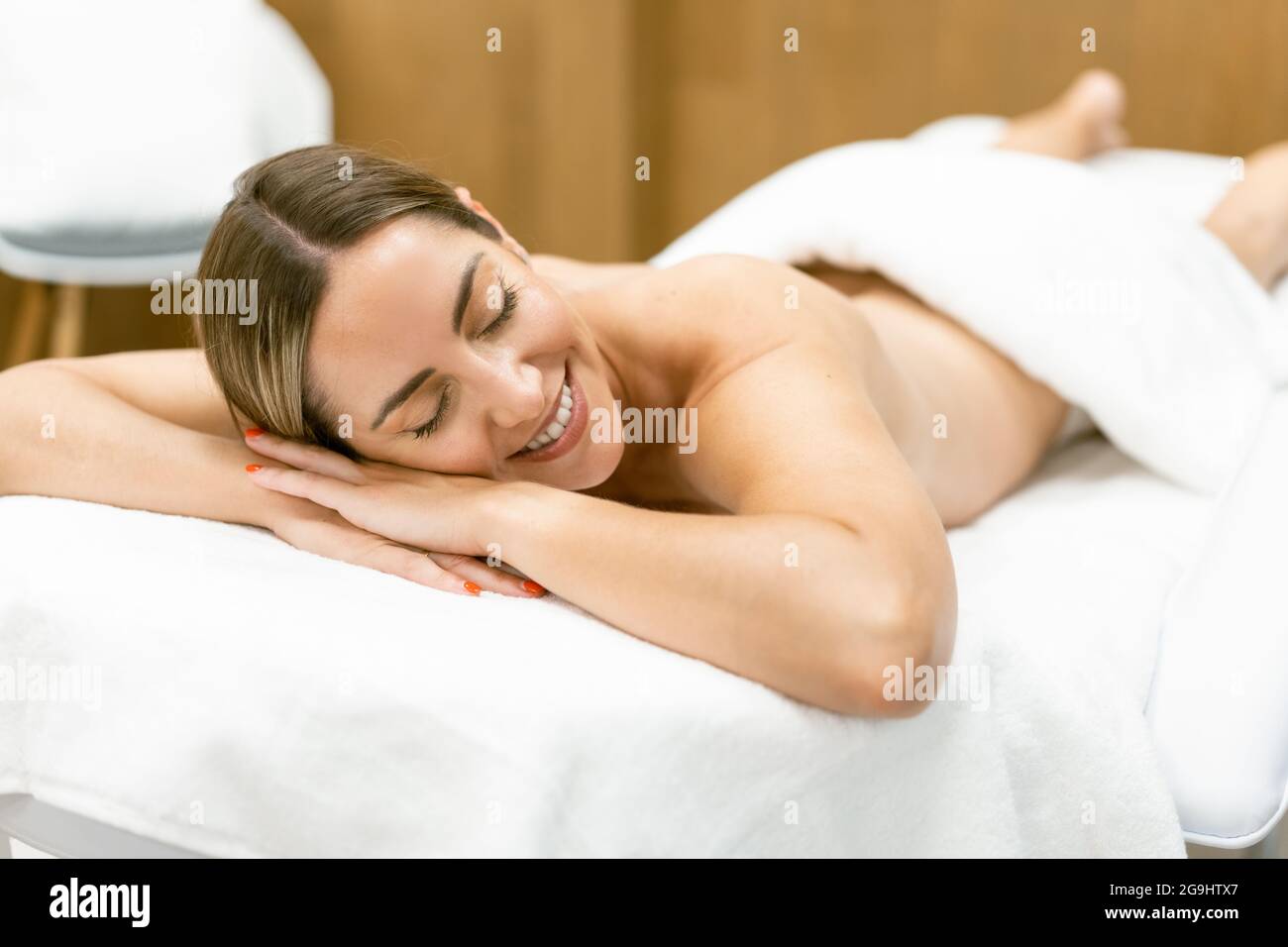 Middle-aged woman lying on a beauty parlour couch for a relaxing massage. Stock Photo