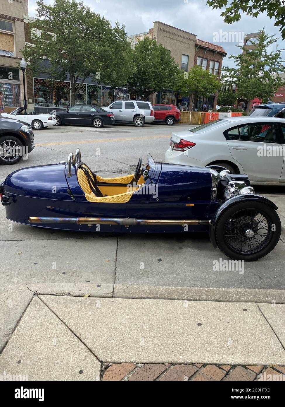 LAWRENCE, UNITED STATES - Jul 10, 2021: A vertical shot of a Morgan three-wheeler classic car-motorcycle at the Mass Street in Lawrence, USA Stock Photo
