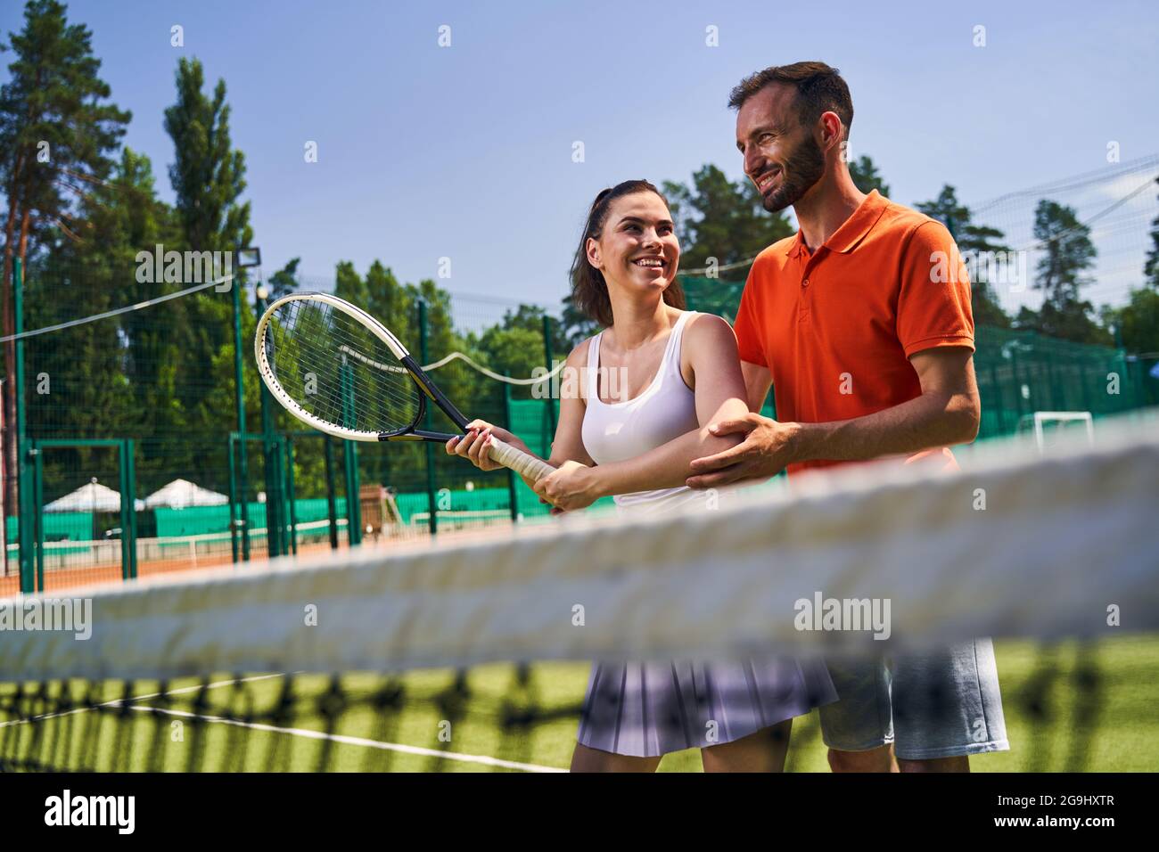Woman learning a proper serve stance during the tennis session Stock Photo