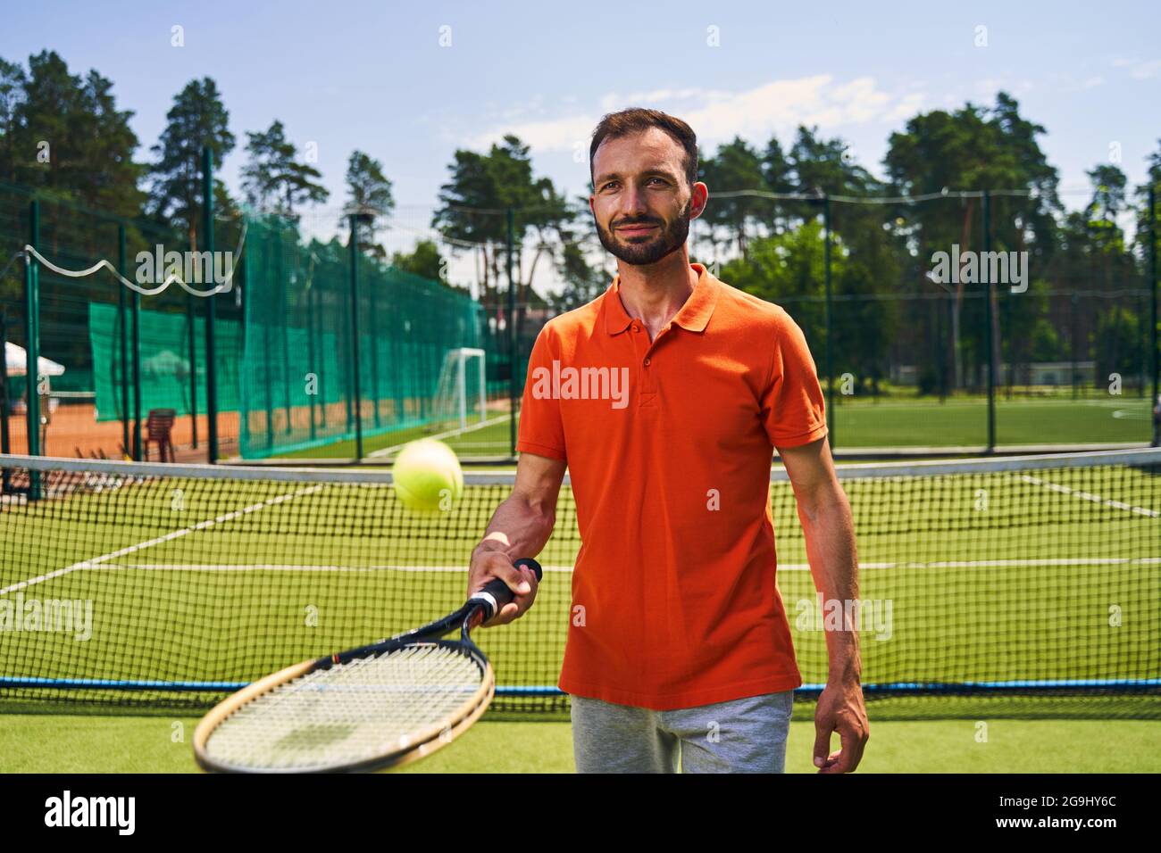 Male beginner tennis player mastering the serve technique Stock Photo