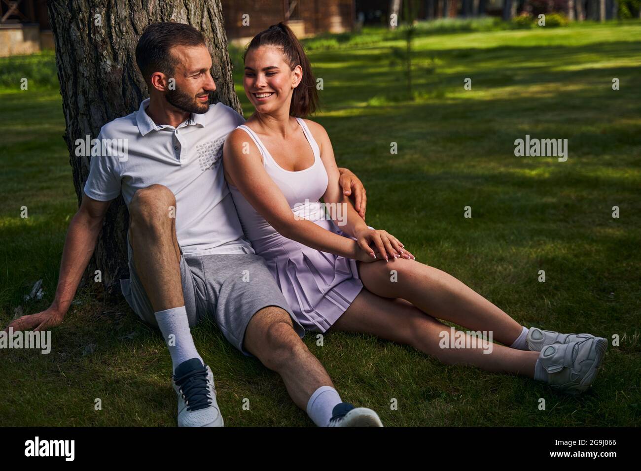 Couple sitting under a tree hi-res stock photography and images - Alamy