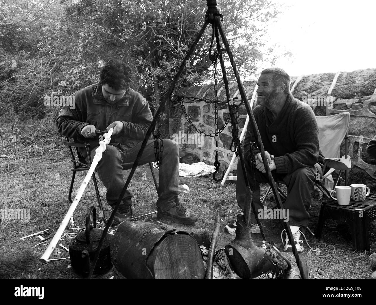 Romany traveller making naturally twisted stick into a walking stick Britain Uk. skills skill craft crafts rural travellers boy man male Stock Photo