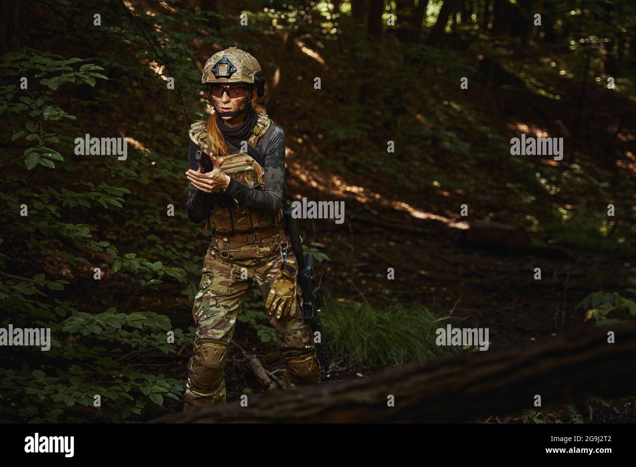 Female person wearing camouflage uniform and helmet Stock Photo