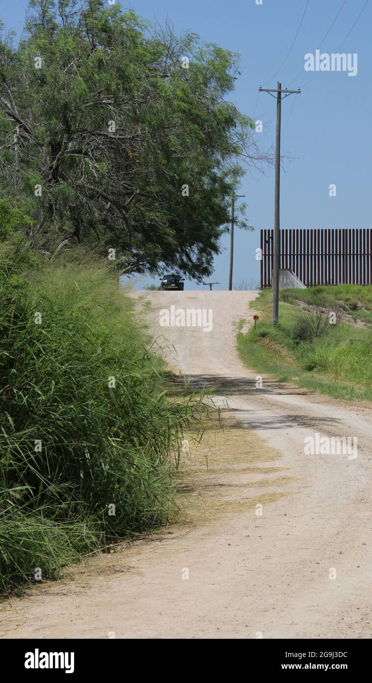 A truck crosses over the border levee in Abram, Texas, USA, on July 23, 2021. In 2007, Congress gave the Department of Homeland Security a year to construct 60 miles of fence in the Rio Grande Valley to protect the border and thus,  negotiated a deal with Hidalgo County Drainage District No. 1. If Homeland Security would pay to repair 22 miles of crumbling dirt levee running along the Rio Grande then the U.S. Government could build their fence on top of them, The Texas Tribune reported. (Photo by Carlos Kosienski/Sipa USA) Stock Photo