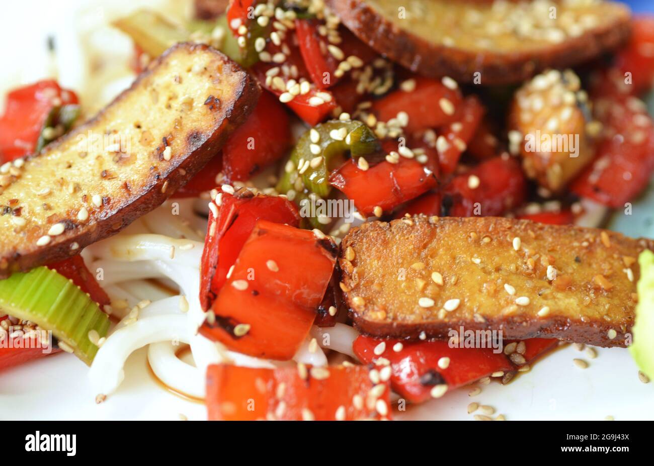 Smoked and grilled tofu with vegetables and sesame on a plate Stock