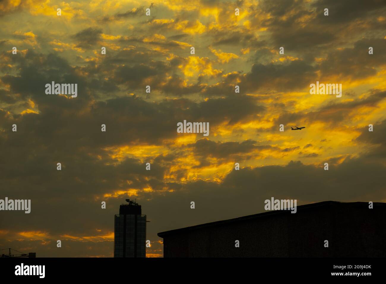 Yellow sunset. Air plane flying at yellow sunset. Partly cludy. Stock Photo