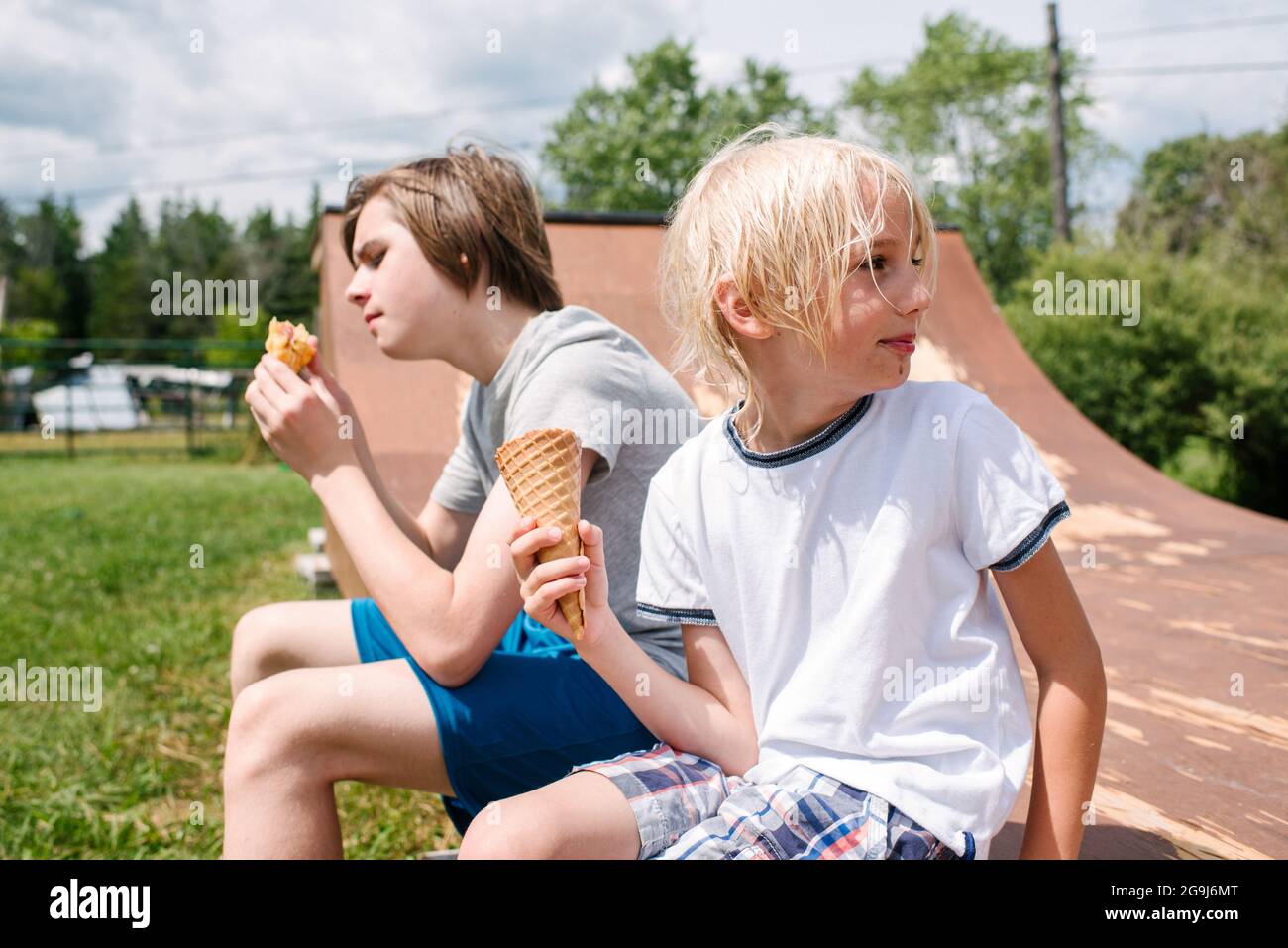 Canada, Ontario, Kingston, Boys (8-9, 14-15) eating ice cream Stock Photo