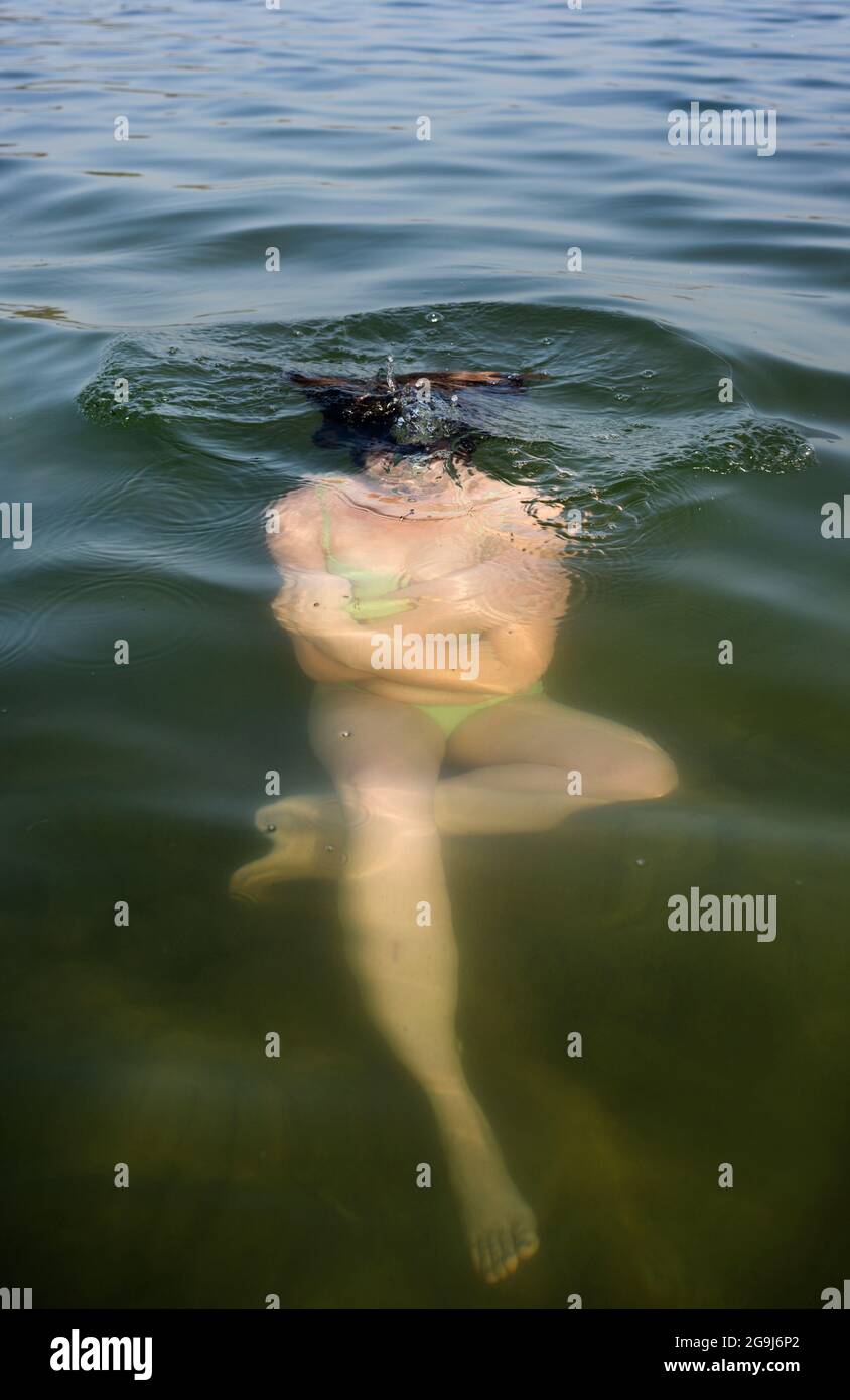 Netherlands, Noord-Brabant, Breda, Woman submerging in lake Stock Photo