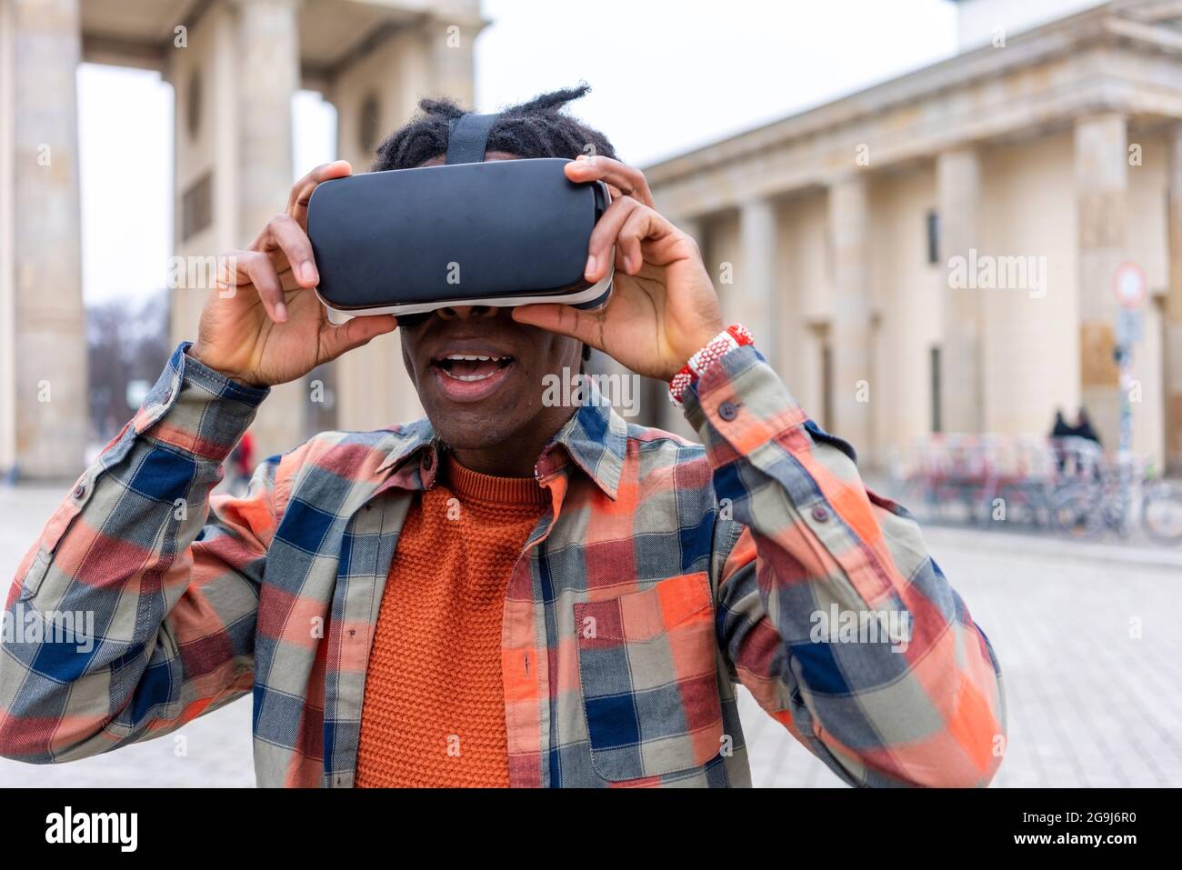 Germany, Berlin, Man using virtual reality goggles in city Stock Photo