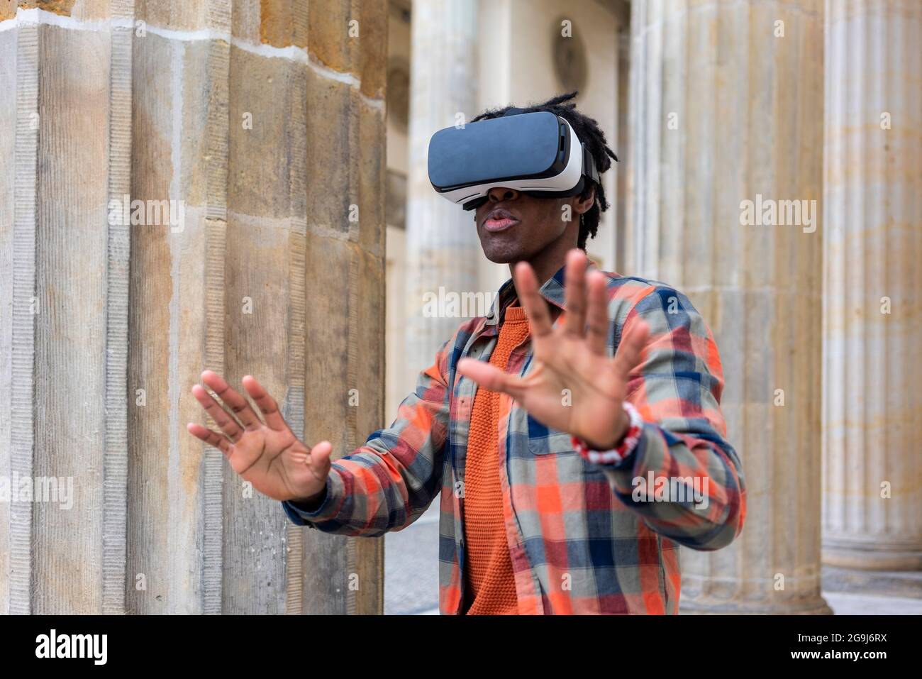 Germany, Berlin, Man using virtual reality goggles in city Stock Photo