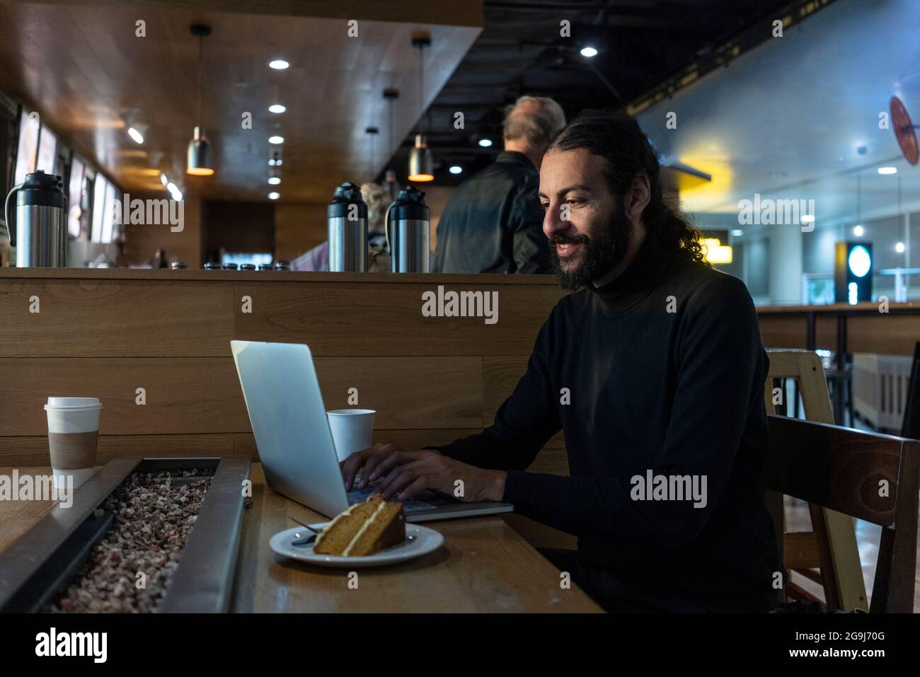 UK, London, Man using laptop at airport cafe Stock Photo