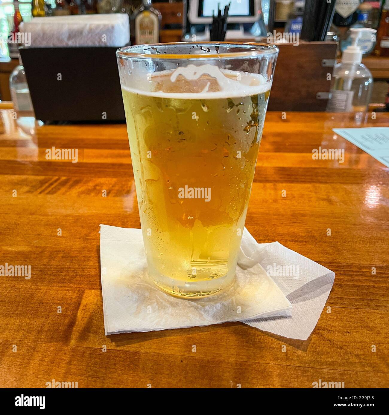 An icy cold draft beer in a glass sitting on a bar in Florida Stock