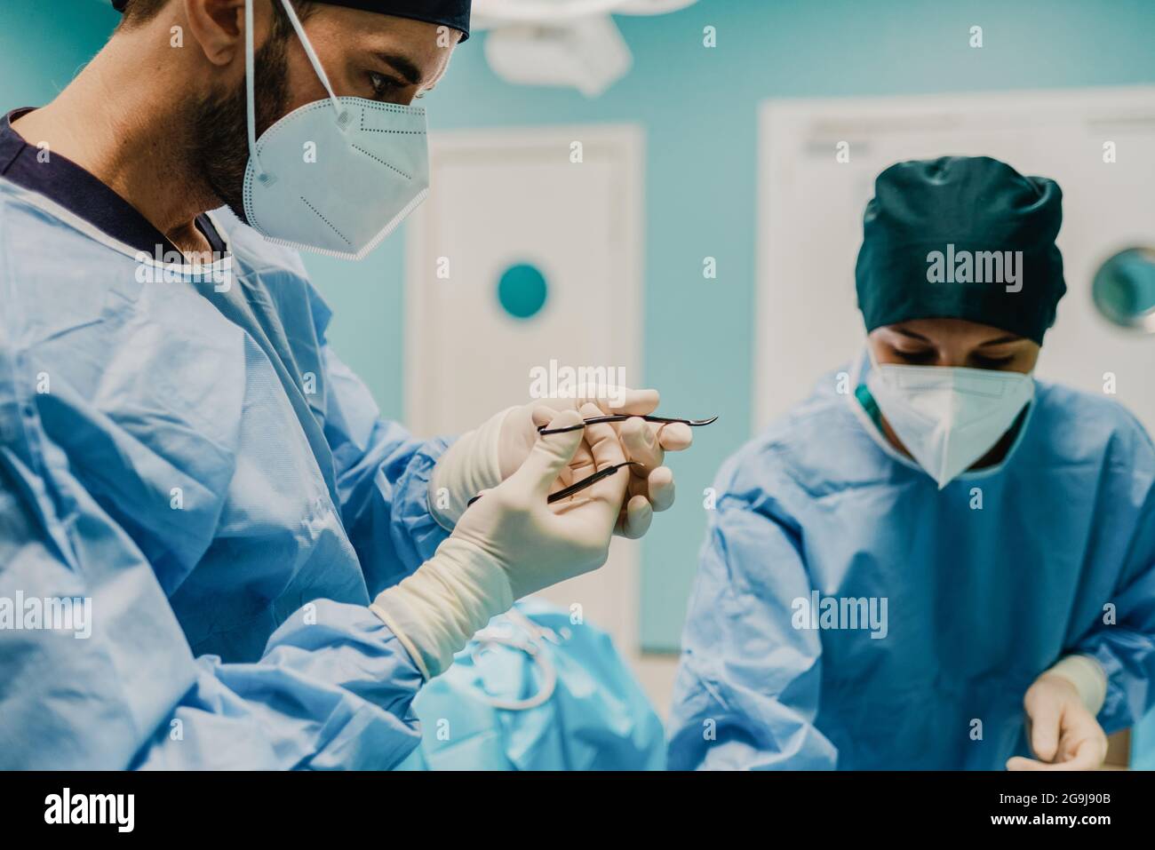 Medical doctors preparing surgical equipment for operation inside private clinic - Focus on male doctor face Stock Photo