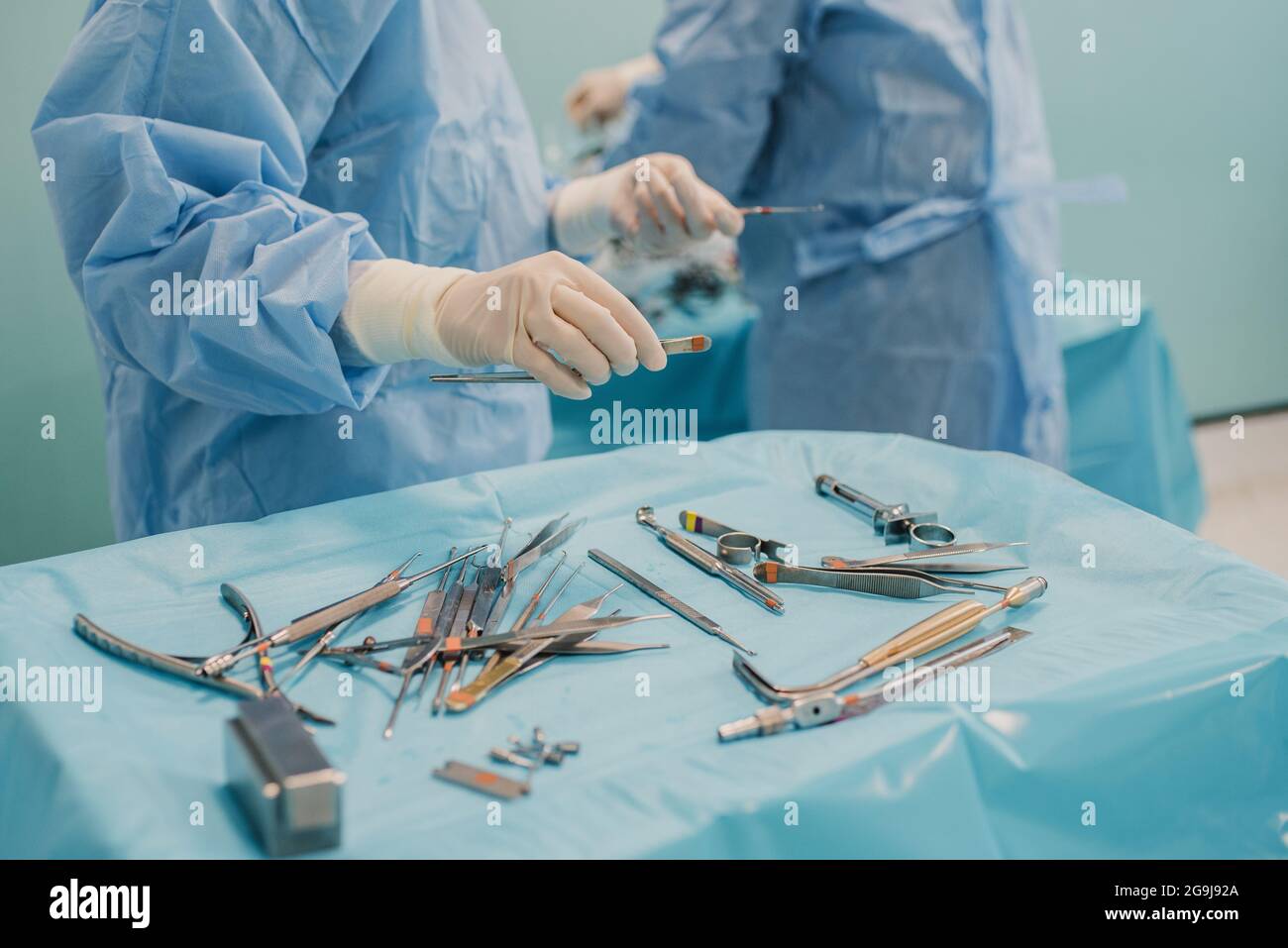 Medical team preparing surgical equipment for operation inside emergency hospital clinic - Focus on left doctor hand Stock Photo