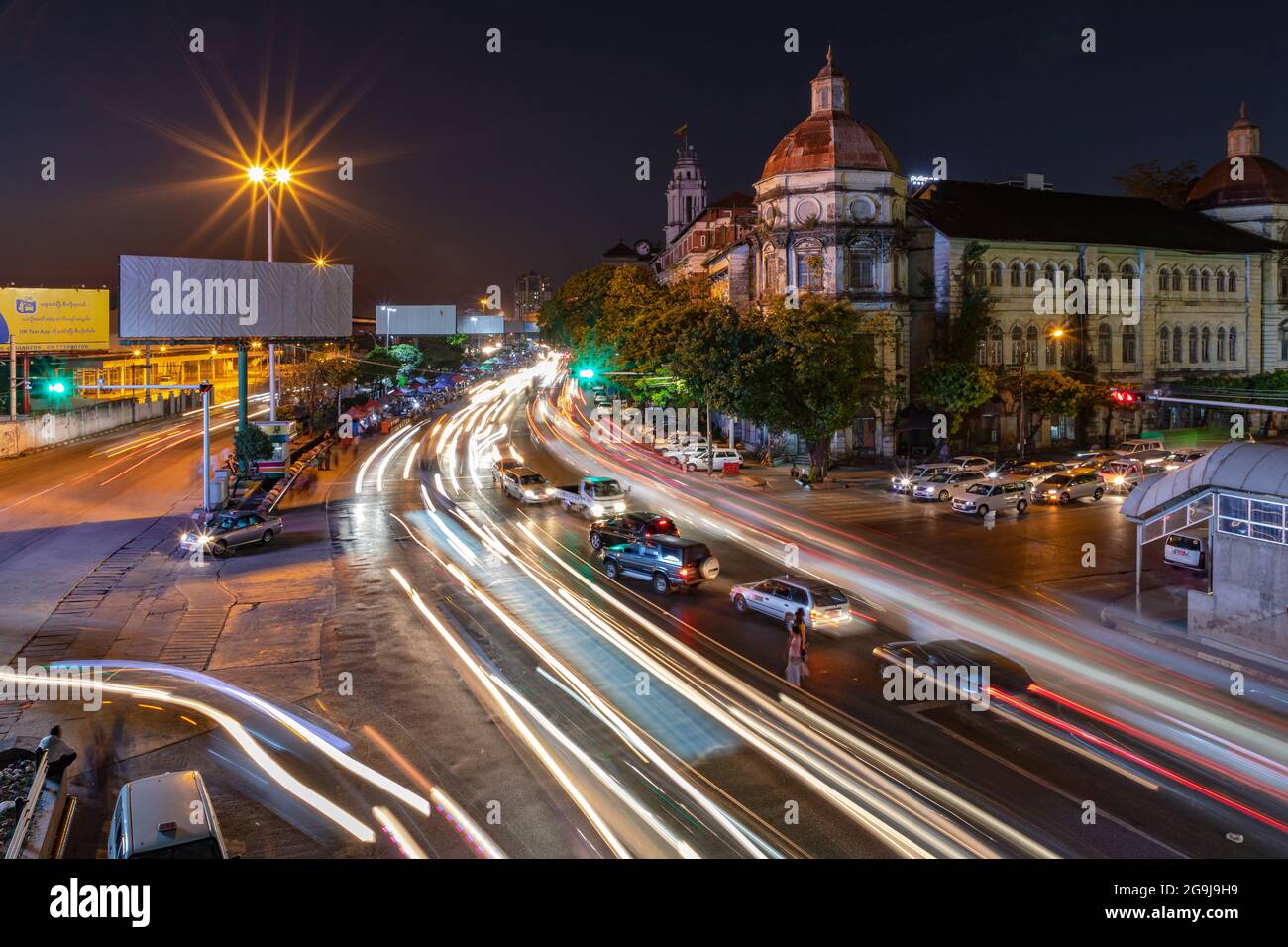 A long exposure night shot of a Yangon main street with beautiful buildings in Myanmar Stock Photo