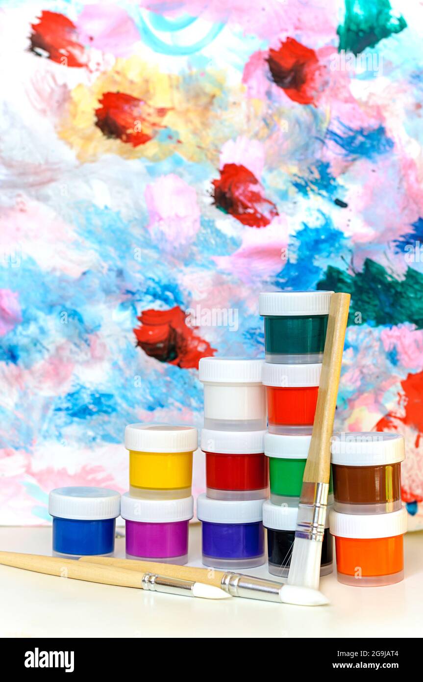 paints and brush. Multi-colored paints and brush on colorful blurred background Stock Photo