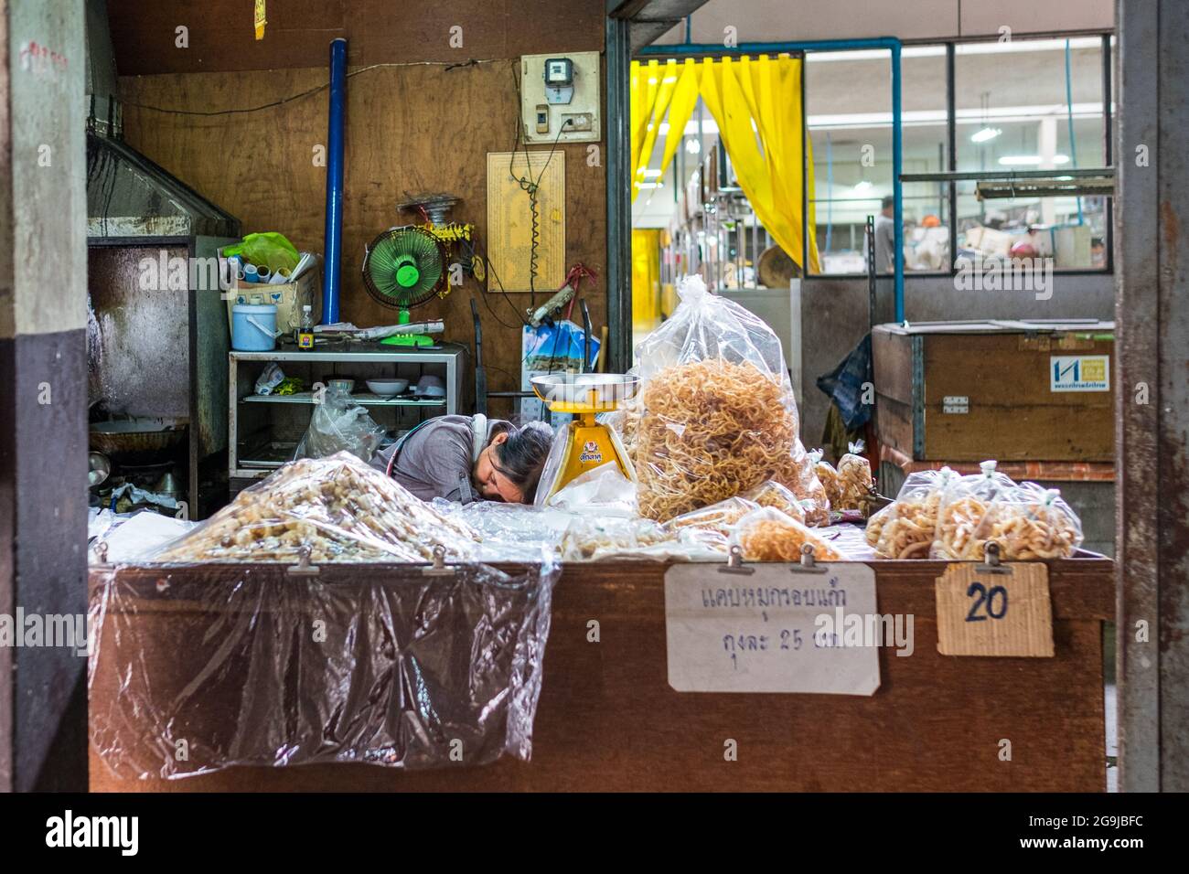 Asian man resting after a hard day's work in the market. Picture is taken in Chang Mai in the foodmarket. Stock Photo