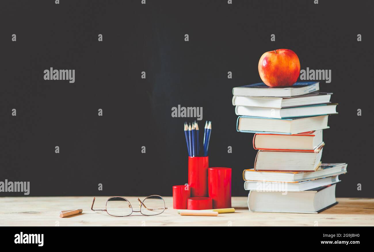 back to school concept pile of books against chalkboard Stock Photo - Alamy