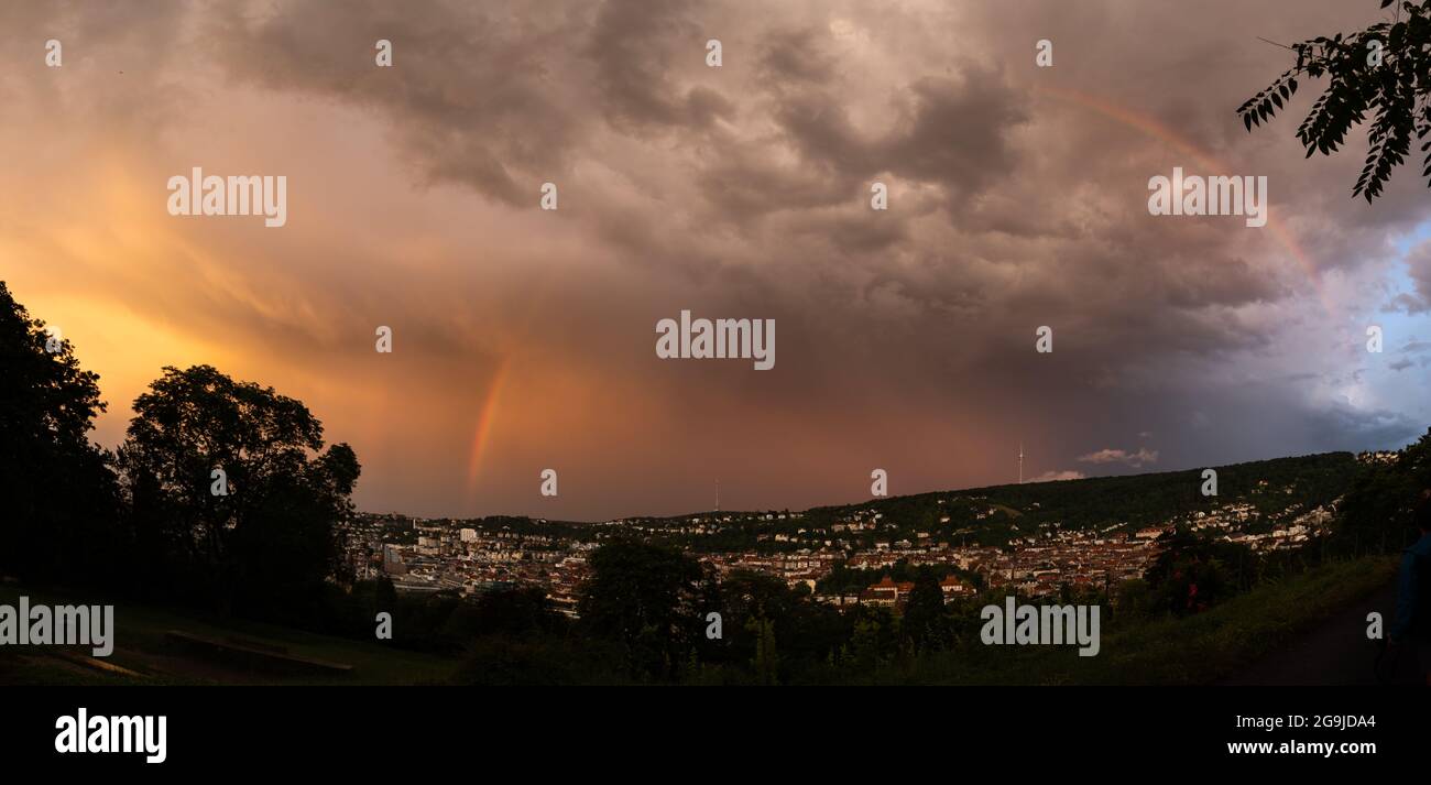 Stuttgart, Germany - July 26, 2021. A thunderstorm is rushing over Stuttgart during the evening hours. Leaving a beautiful colorful view with rainbow. Stock Photo