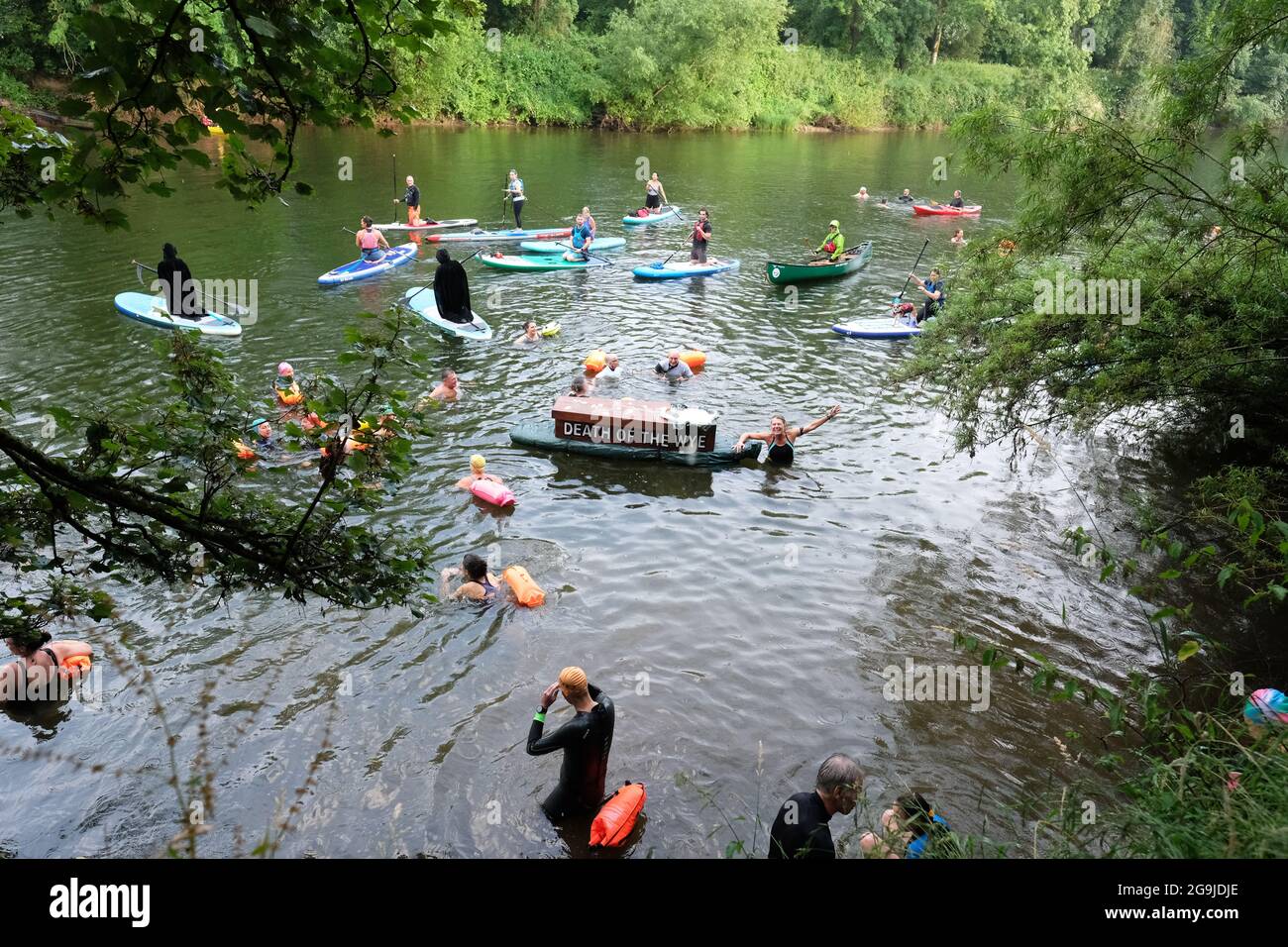 Monmouth, Monmouthshire, Wales, UK – Monday 26th July 2021 – Wild swimming coach Angela Jones leads a swim along the River Wye at Monmouth pulling a mock coffin to protest about the pollution in the Wye. The River Wye has high levels of nitrates and phosphates which protesters say comes from the many intensive poultry farms and the muck spreading of waste beside the the river as the Wye passes through the counties of Powys, Herefordshire and Monmouthshire. Photo Steven May / Alamy Live News Stock Photo