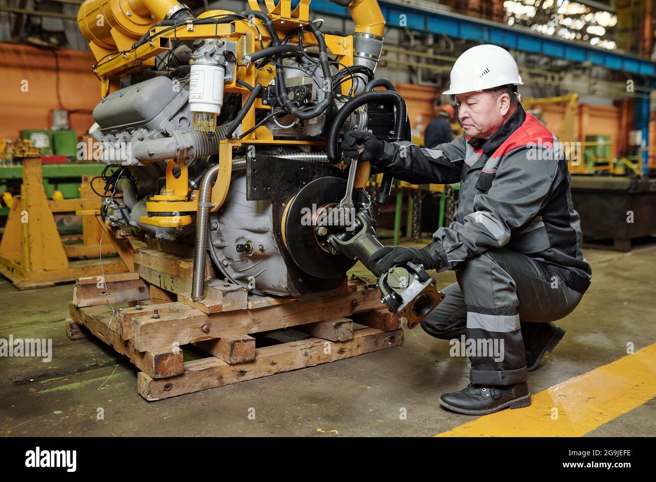 Manual worker in helmet examining the metal equipment in the machinery factory Stock Photo
