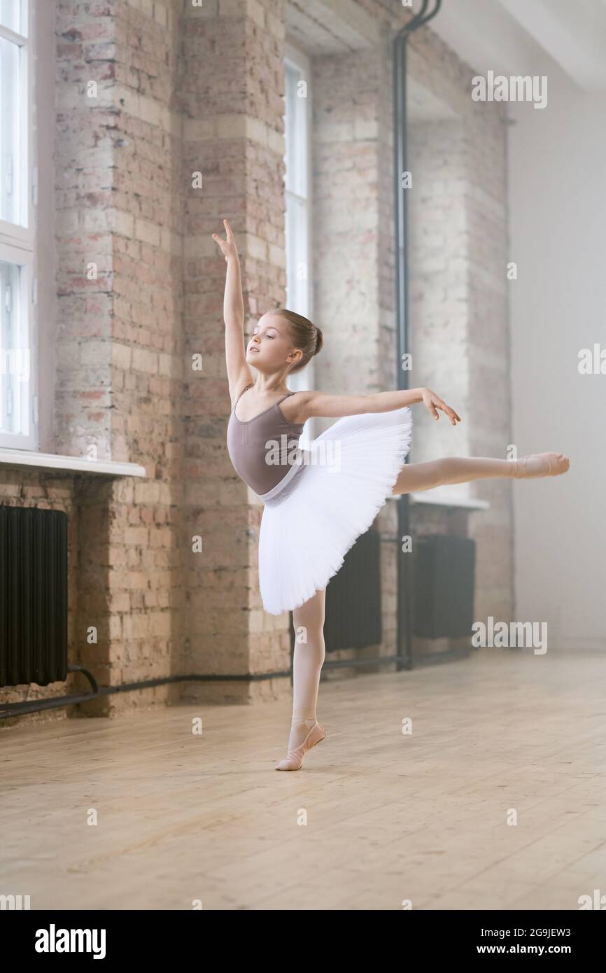 Portrait of little girl in tutu dress and shoes preparing for a ballet