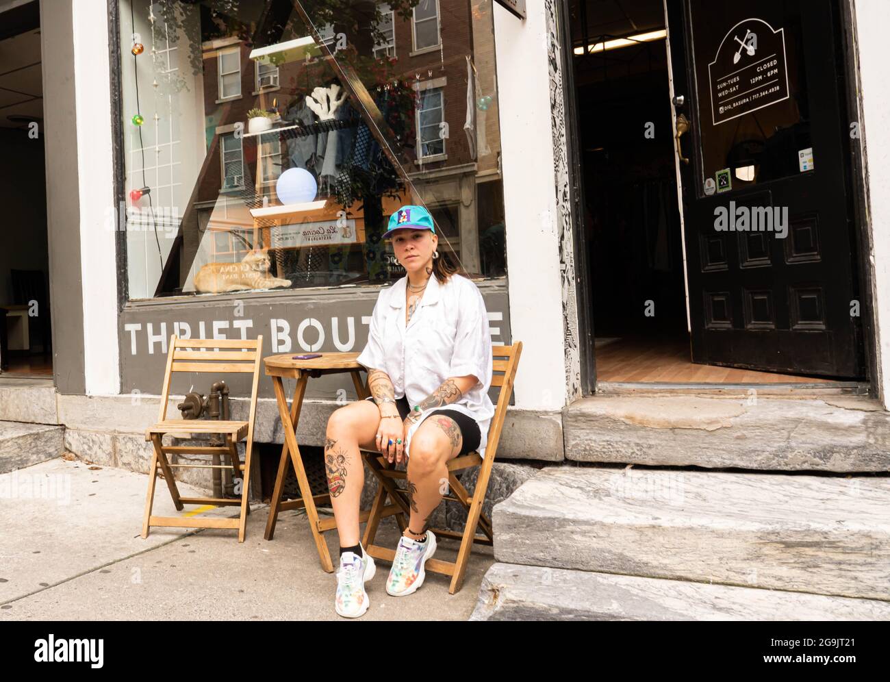 Vintage clothes shop owner sitting in front of the store in Lancaster