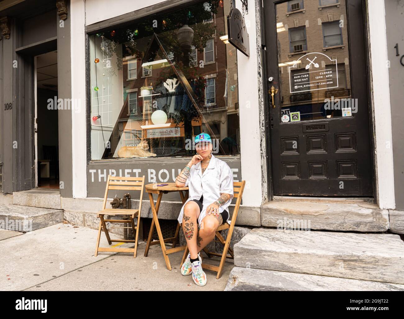 Vintage clothes shop owner sitting in front of the store in Lancaster city, Pennsylvania, USA on July, 2021 Stock Photo