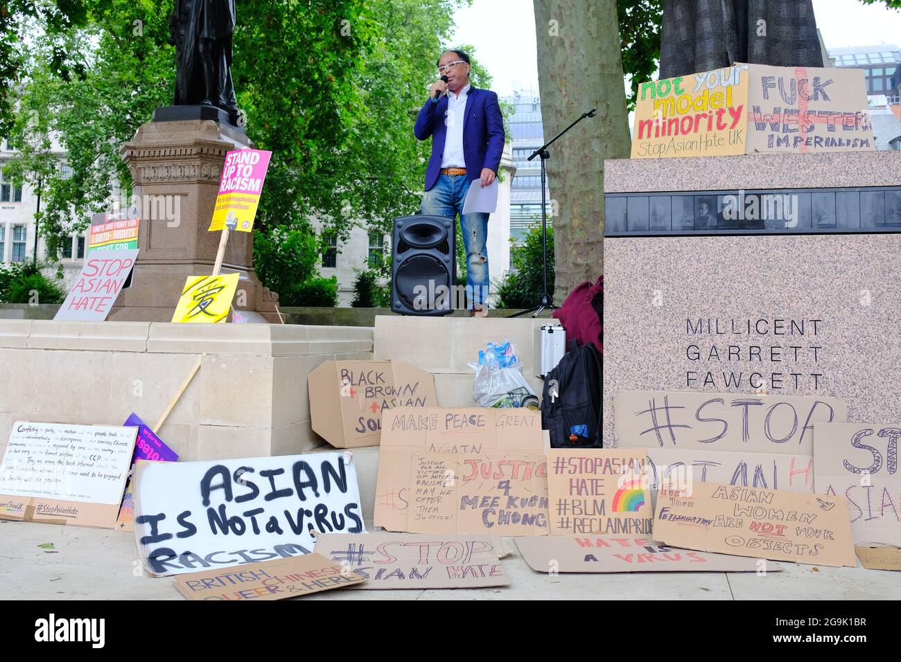 Surrounded by placards, a speaker at a Stop Asian Hate rally describes his experiences of racism. Stock Photo