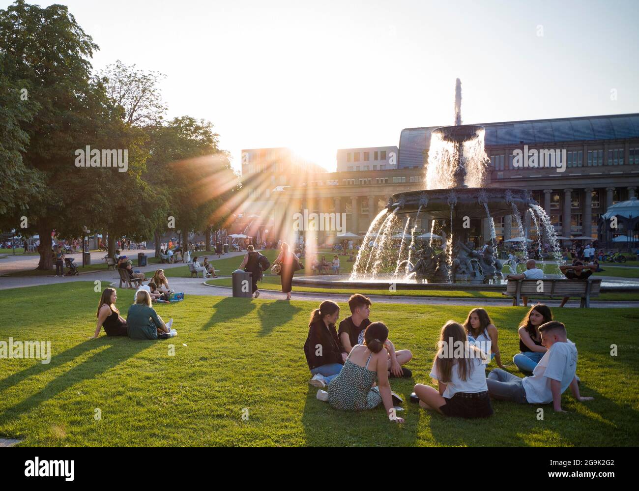 Young people enjoying summer evening on Schlossplatz in front of Koenigsbau, Stuttgart, Baden-Wuerttemberg, Germany Stock Photo