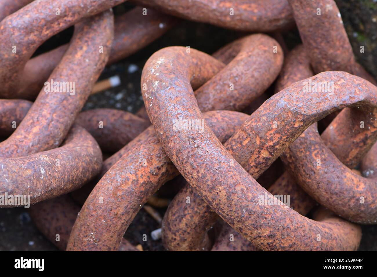 Pile of heavy links of thick chain with surface corrosion. Stock Photo