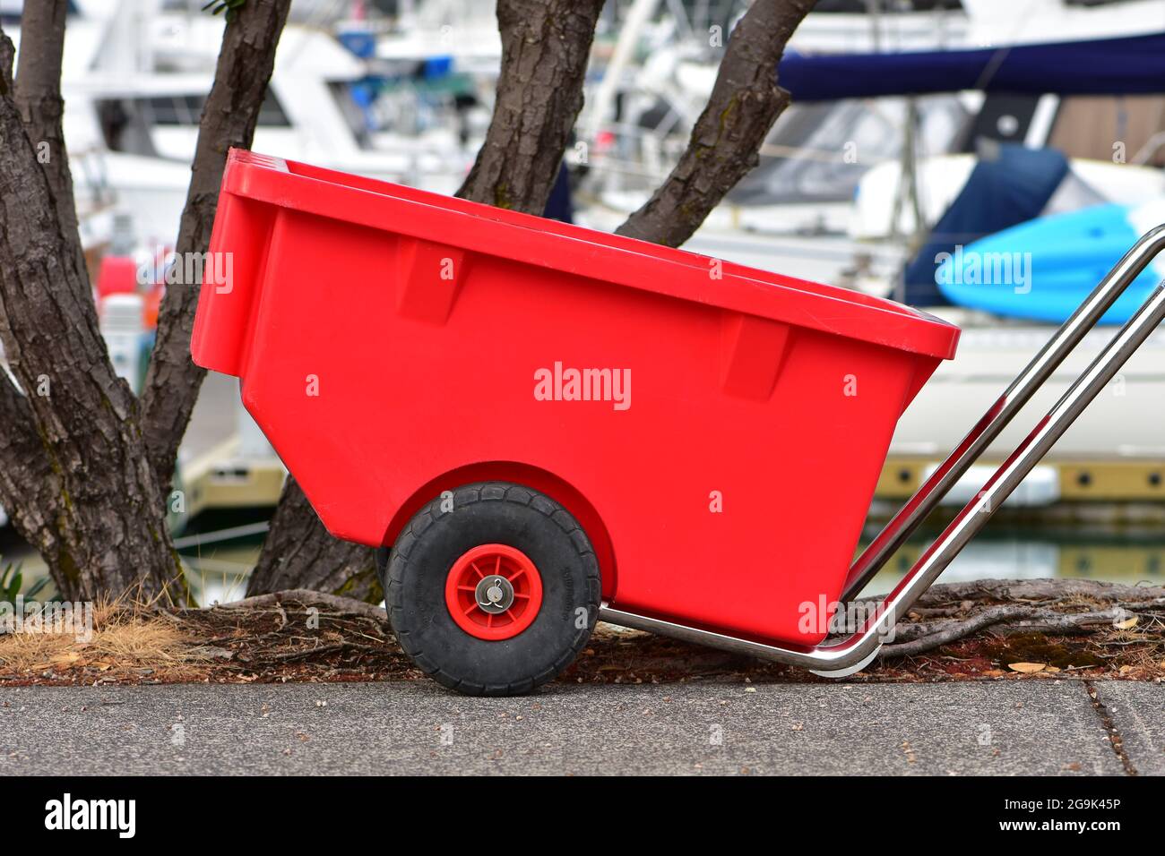 Heavy duty marina cart with stainless steel frame and red plastic basket. Stock Photo