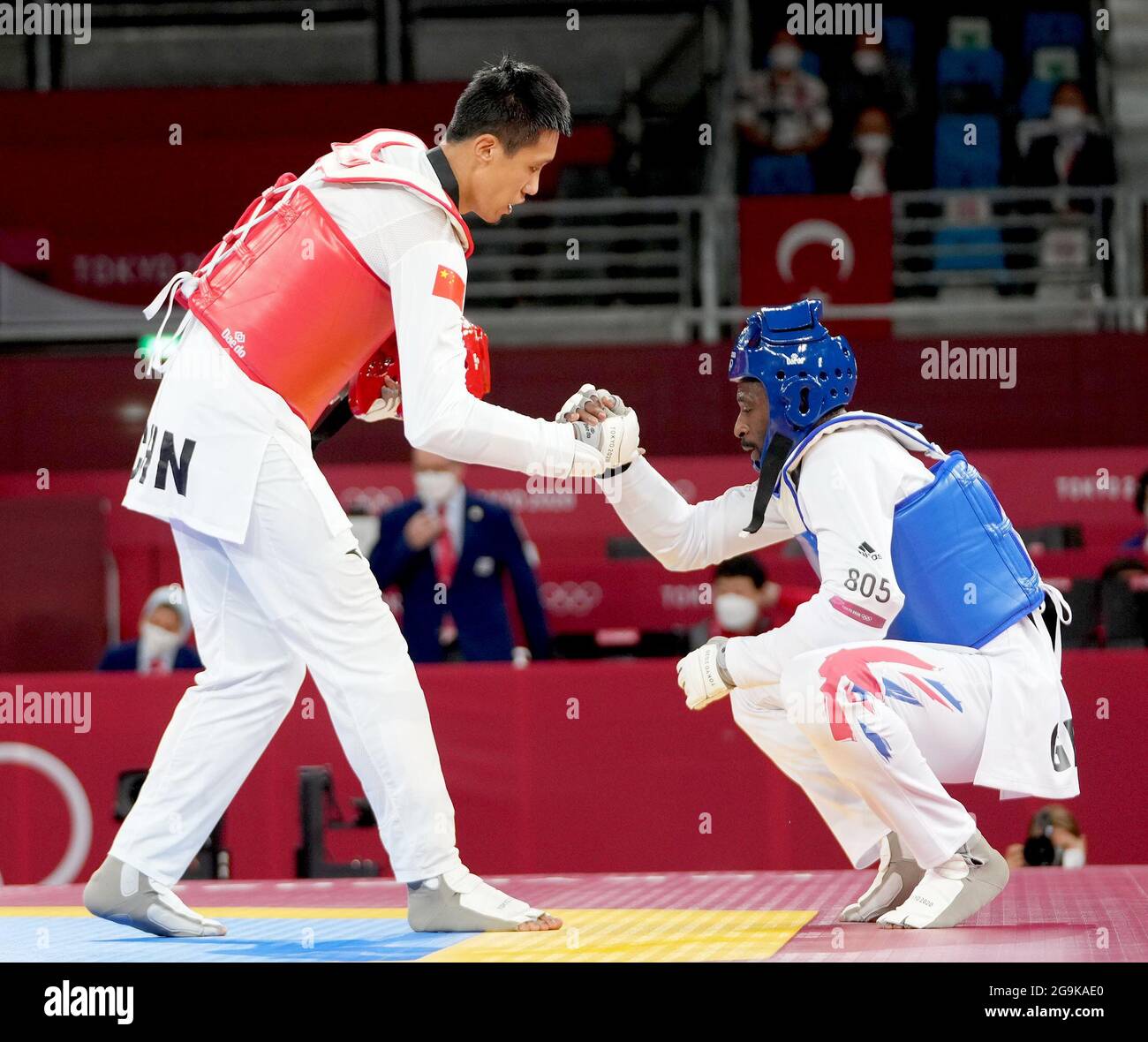 Tokyo, Japan. 27th July, 2021. Sun Hongyi of China (L) shakes hands with Mahama Cho of Britain during the men's 80kg  taekwondo round of 16 match at the Tokyo 2020 Olympic Games in Tokyo, Japan, July 27, 2021. Credit: Wang Yuguo/Xinhua/Alamy Live News Stock Photo