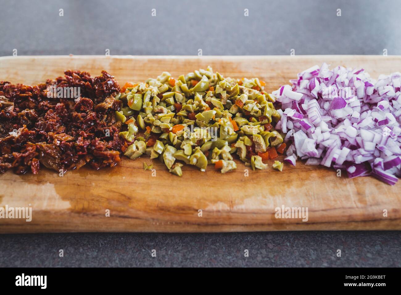 onion sundried tomatoes and oliced diced and chopped on cutting board ...