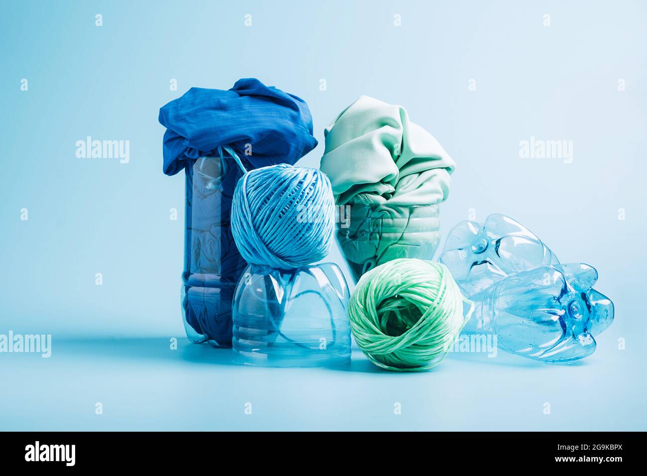 Empty plastic bottle and various fabrics made of recycled polyester fiber synthetic fabric on a