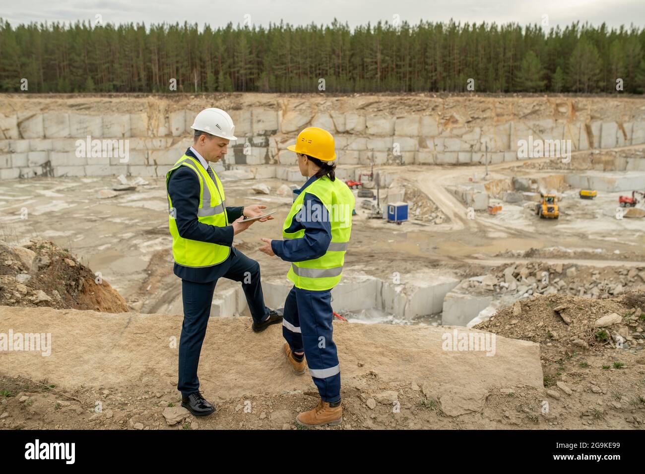 Young foreman and female engineer interacting at construction site Stock Photo