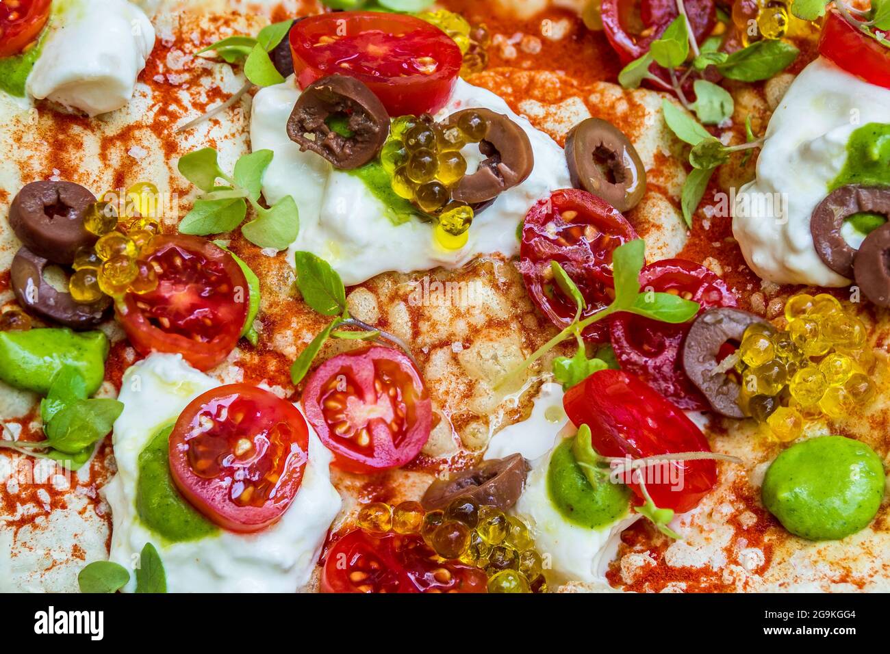 Gourmet Pizza Surface with Burrata, Balsamic Pearls, Cherry Tomatoes, and Pesto Stock Photo