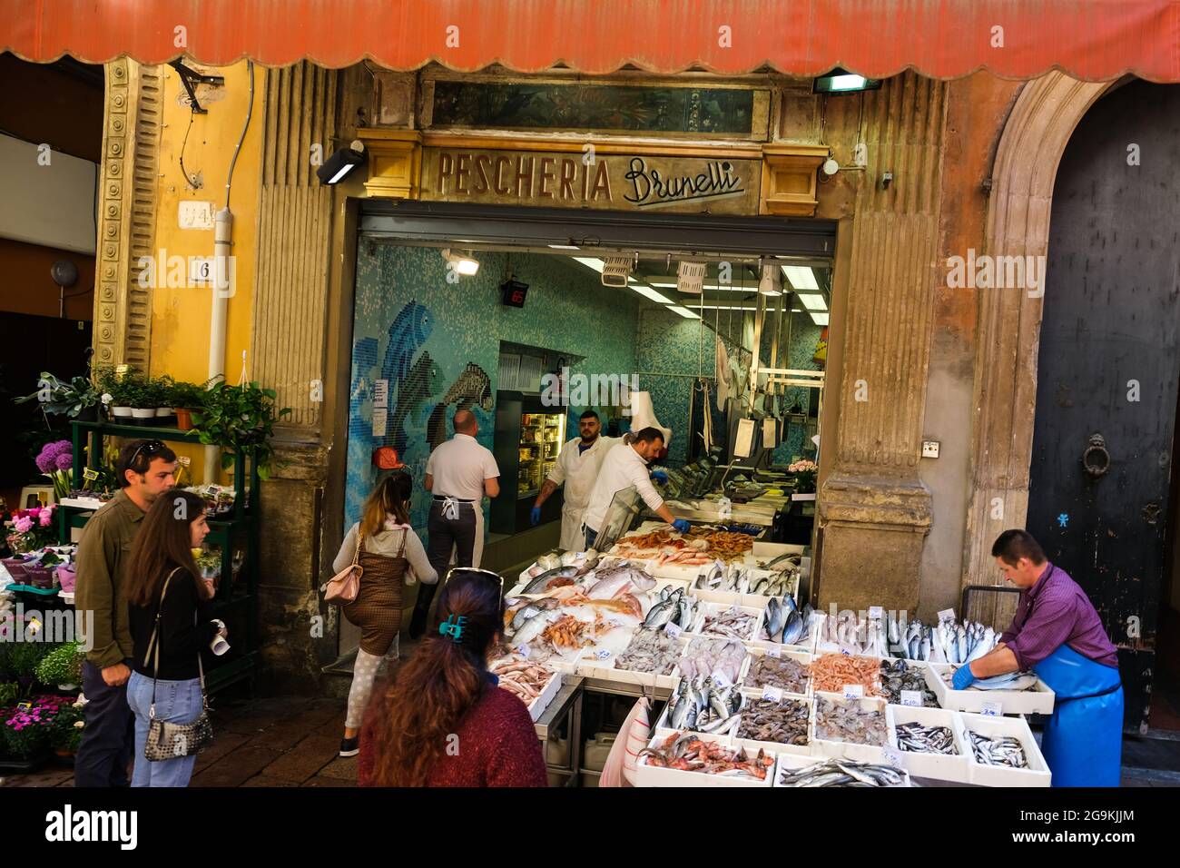 Shoppers buying fish and other seafood at a shop in the Quadrilatero area of Bologna Italy Stock Photo