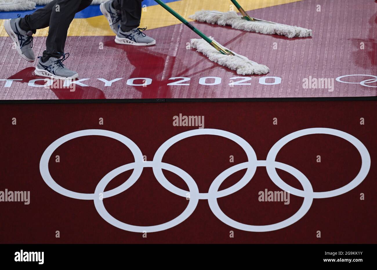 Chiba, Japan. 27th July, 2021. Taekwondo: Olympics, preliminaries, quarterfinals, men  80 Kg, at Makuhari Messe Hall. Helpers clean the ring with the lettering 'Tokyo 2020'. Credit: Swen Pförtner/dpa/Alamy Live News Stock Photo