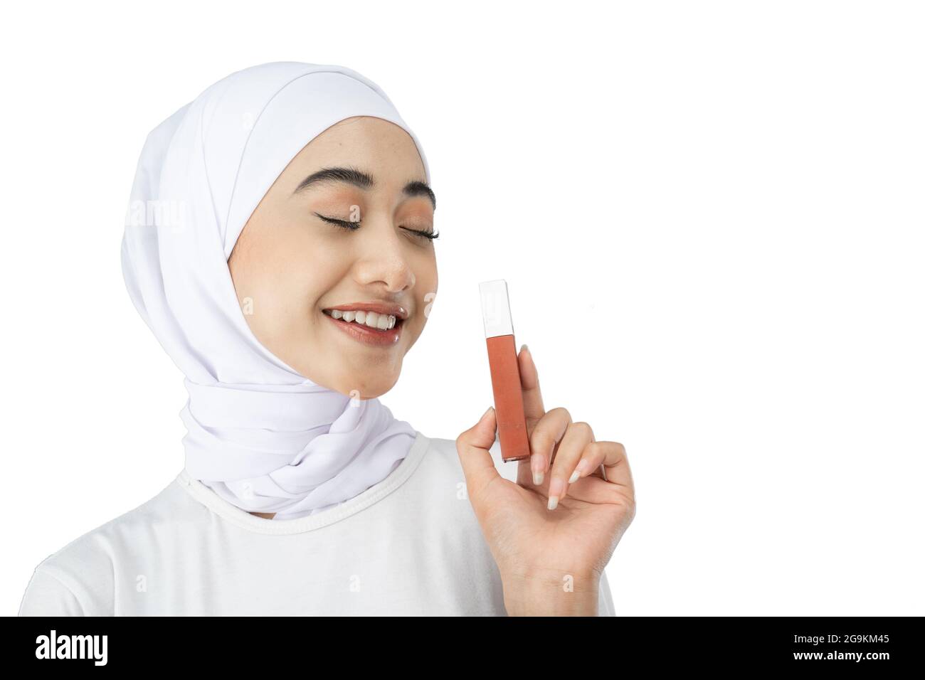 Beautiful Muslim woman in hijab closes eyes while holding lipstick ...
