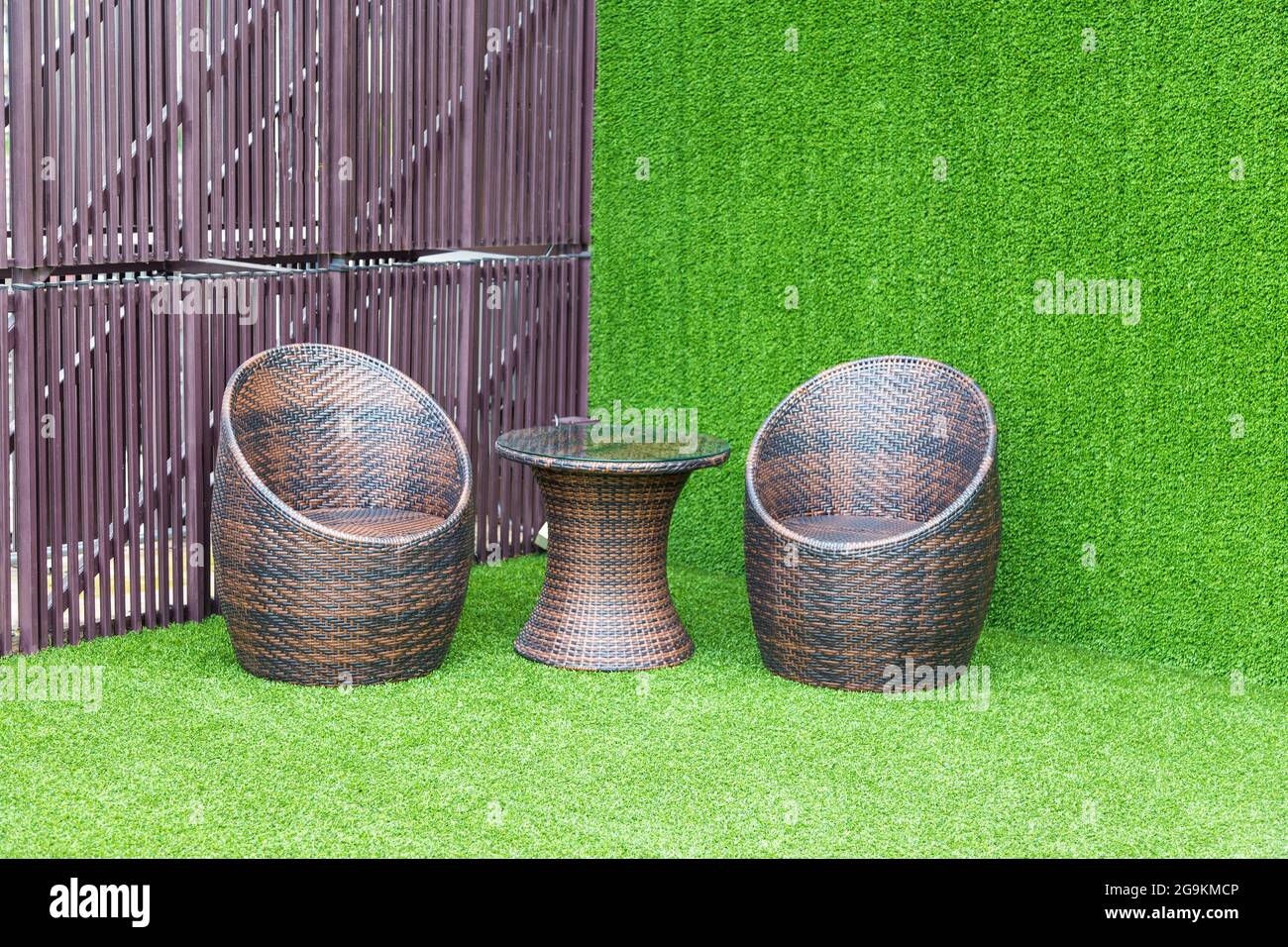 Brown wicker chair on the green background Stock Photo - Alamy