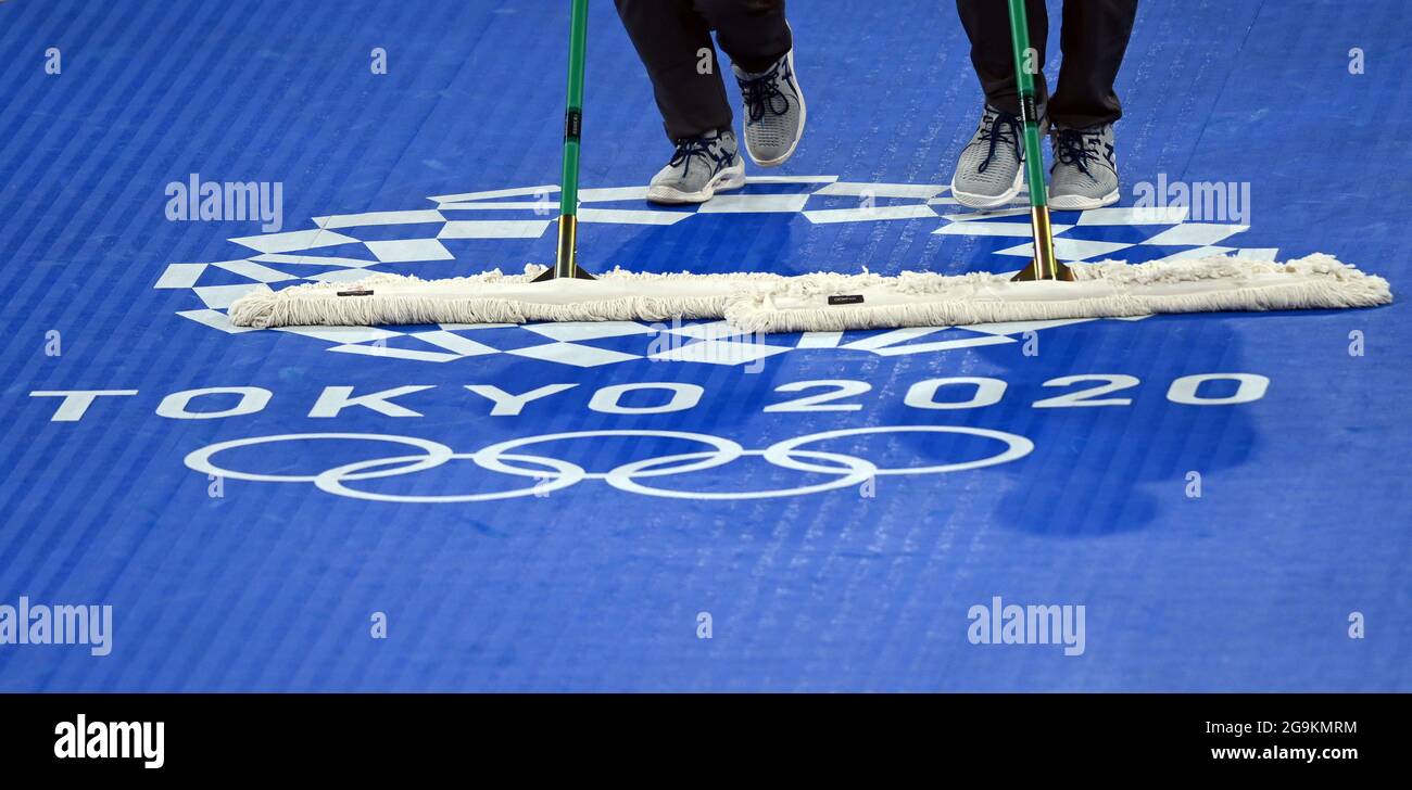 Chiba, Japan. 27th July, 2021. Taekwondo: Olympics, preliminaries, quarterfinals, men  80 Kg, at Makuhari Messe Hall. Helpers wipe the ring with the logo of the Games. Credit: Swen Pförtner/dpa/Alamy Live News Stock Photo