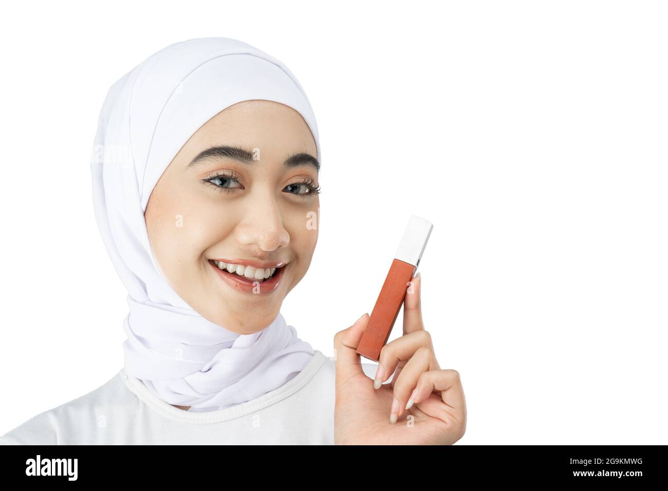 Beautiful Muslim woman in hijab smiling while holding lipstick bottle ...