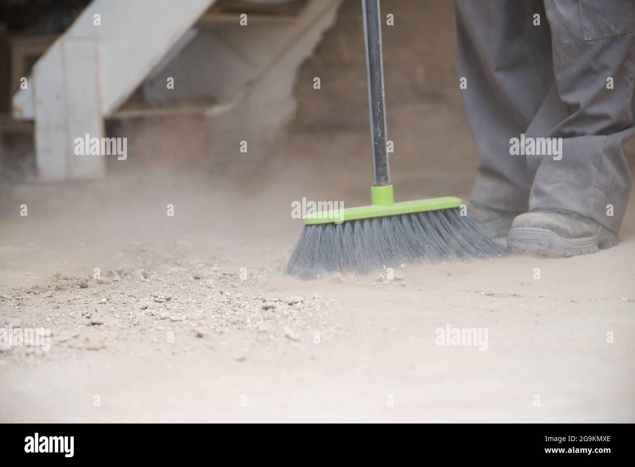 Close up of a young caucasian construction worker sweeping the floor at
